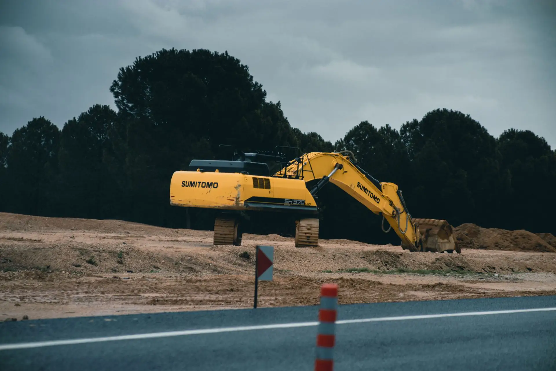 A tracked excavator working on a cleared site on an overcast day